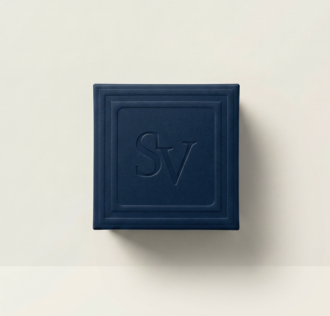 Embossed SV monogram on a dark navy box